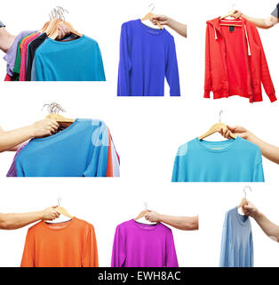 men hand holding hangers with sweaters and t-shirts Stock Photo