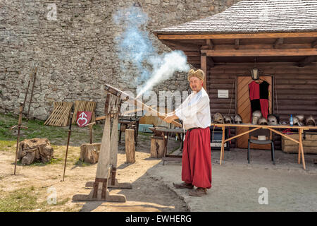 Man firing old shotgun in Checiny Castle, Poland Stock Photo