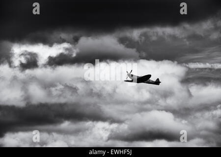 Spitfire and moody clouds at Bicester flywheel festival. Oxfordshire, England. Monochrome Stock Photo