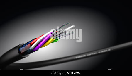 Stripped fiber optic cable over black background with spot light, communication network technology. Stock Photo