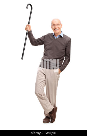 Full length portrait of a senior gentleman showing his cane and leaning against a wall isolated on white background Stock Photo