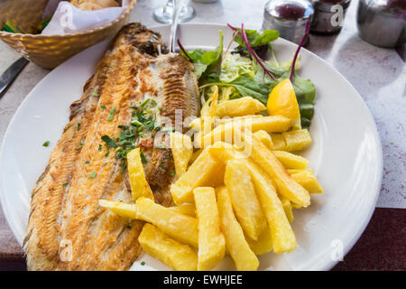 Grilled Dover sole and crispy golden chips (French fries) at a seafood restaurant in Brighton, East Sussex, UK Stock Photo