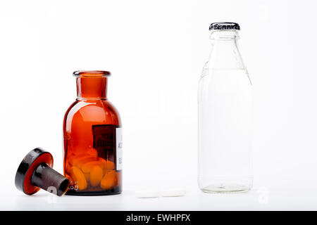 Bottle of water, a glass medicine bottle and white pills on white background Stock Photo