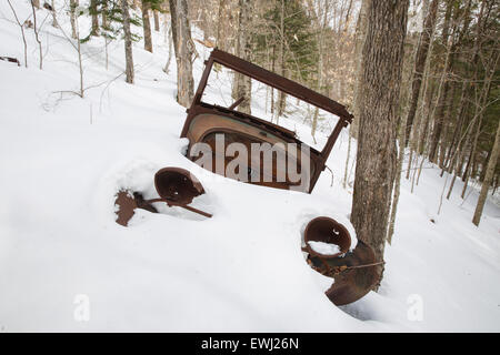 Rusted car in the Eastman Brook drainage of Thornton, New Hampshire USA during the winter months. This is possibly a late 1920s  Stock Photo