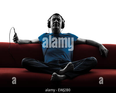 one caucasian man sofa couch listening music audio  in silhouette isolated on white background Stock Photo