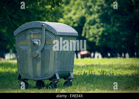 Green dumpster in forest for tourists Stock Photo