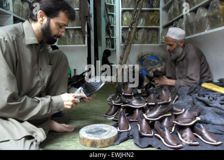 Peshawar. 27th June, 2015. Pakistani people make traditional Peshawari Chappal at a workshop in northwest Pakistan's Peshawar, June 27, 2015. Peshawari Chappal is a traditional footwear of Pakistan, worn especially by Pashtuns in the Khyber Pakhtunkhwa region of Pakistan. © Ahmad Sidique/Xinhua/Alamy Live News Stock Photo