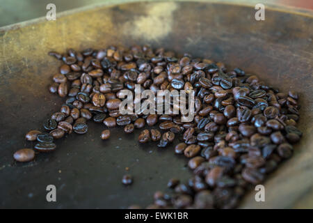 Freshly roasted organic Colombian coffee cooling in a wooden bowl. Stock Photo