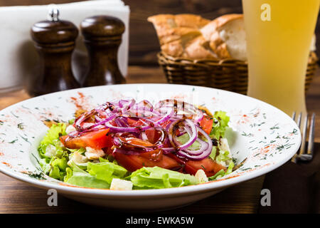 meat salad with spices and vegetables with light beer on on wooden table Stock Photo