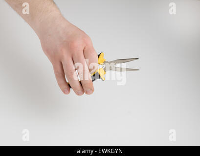 the human hand holds the pliers on a white background Stock Photo