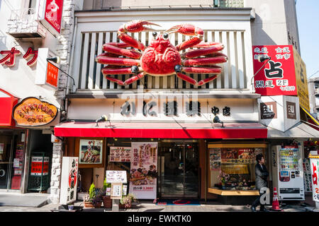 Popular Kanidooraku restaurant entrance with it's large mechanical moving orange crab sign above the door in Dotonbori, Osaka. Stock Photo