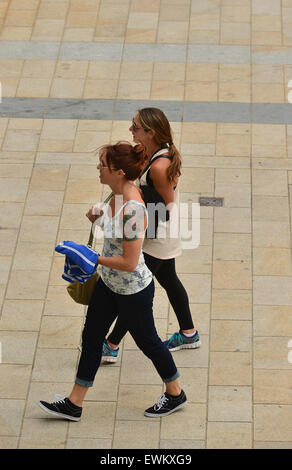 Two young woman walking together in Londonderry (Derry), Northern Ireland, one with tattoo on shoulder. Stock Photo