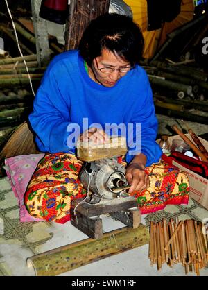 Chiang Mai, Thailand:   Thai woman uses an electric sander on a block of wood at the Sa Paper & Umbrella Handicraft Centre * Stock Photo