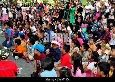 Chiang Mai, Thailand:  A rapt audience of school children watching a performance during an outdoor assembly Stock Photo