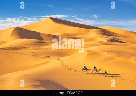 Morocco - tourists ride on camels, Erg Chebbi desert near Merzouga, Sahara Stock Photo