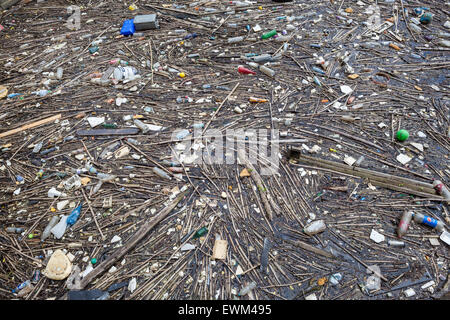 Plastic rubbish and other non-degradable waste in water of canal Stock Photo