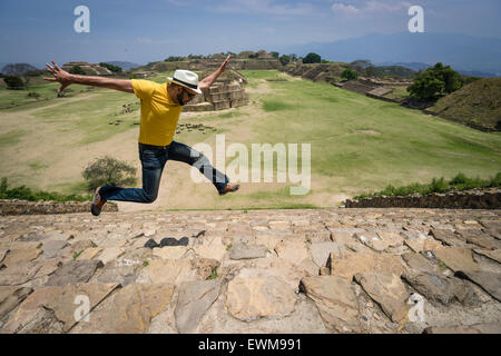Hispanic man jumping for joy on the stone steps of Monte Alban ruins in Mexico Stock Photo