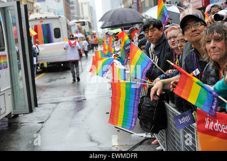 Toronto, Canada. 28th June 2015. Pride Toronto Parade watchers waiting along the parade route in rain in downtown Toronto. Credit:  EXImages/Alamy Live News Stock Photo