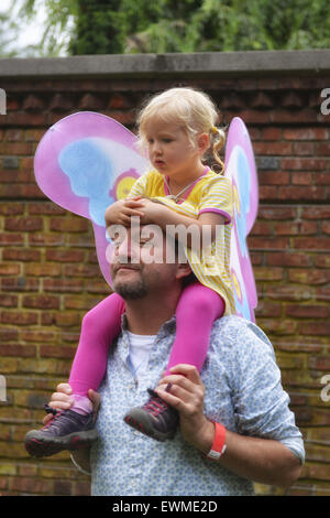 June 28, 2015 - Old Westbury, New York, United States - A young girl, dressed in a fairy costume, sits on shoulders of father, as they watch dancers, on grounds of historic Old Westbury Gardens, a Long Island Gold Coast estate, during its Midsummer Night event. (Credit Image: © Ann Parry/ZUMA Wire) Stock Photo