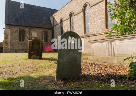 homeless no where to live so put up in red tent in churchyard charitable act helping left alone in Chelmsford city Stock Photo