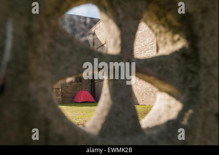 homeless no where to live so put up in red tent in churchyard charitable act helping left alone in Chelmsford city Stock Photo