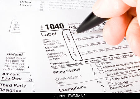 Stock image of man filling out 1040 Tax form Stock Photo