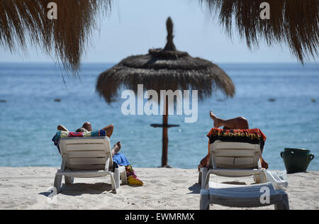 Two tourists lays  on the beach where only two days earlier, a terrorist shot dead beach goers in front of the Hotel Imperial Marhaba in Sousse, Tunisa, 28 June 2015. At least 38 people lost their lives in the terrorist attack in Tunisia, mostly holiday makers. Photo: Andreas Gebert/dpa Stock Photo