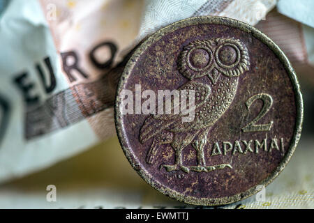 Duesseldorf, Germany. 29th June, 2015. ILLUSTRATION - A Greek drachma coin is on display positioned next to a scrunched up Euro banknote in Duesseldorf, Germany, 29 June 2015. Photo: Federico Gambarini/dpa/Alamy Live News Stock Photo