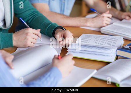 close up of hands with books writing to notebooks Stock Photo