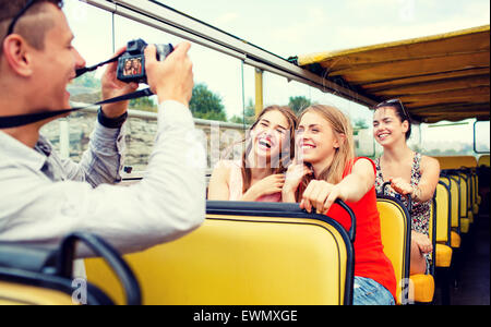 laughing friends with camera traveling by tour bus Stock Photo