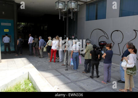 Athens, Greece. 29th June, 2015. People line up at an ATM outside a National Bank branch in Athens, capital of Greece, on June 29, 2015. Greek banks will stay closed before July 6, one day after a planned referendum on bailout proposals, and ATM withdrawals will be limited to 60 euros (65 U.S. dollars) a day per bank card in the same period, the government said early Monday. © Marios Lolos/Xinhua/Alamy Live News Stock Photo