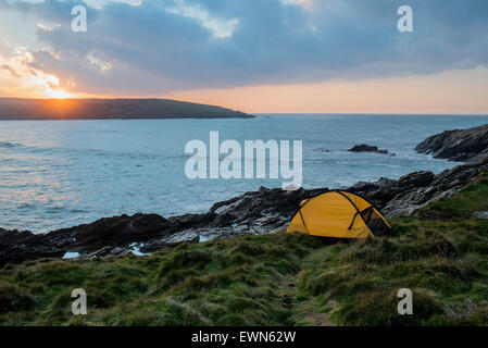 Wild camping by the sea at sunset in Cornwall, UK Stock Photo