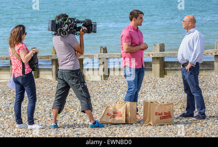 Gregg Wallace and Chris Bavin filming for the Eat Well for less TV show on a beach in Littlehampton, West Sussex, England, UK. Stock Photo