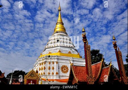 Chiang Mai, Thailand:  A photograph of King Bumibhol stands in front of the i white Chedi at Wat Chang Yuen Stock Photo