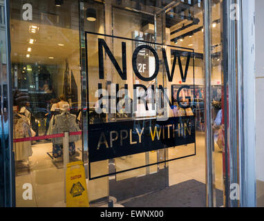 A sign on the window of a Forever 21 clothing store in New York advertises that it is 'Now Hiring' on Friday, June 26, 2015. (© Richard B. Levine) Stock Photo