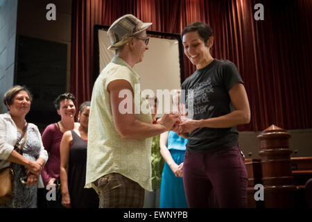 Catherine Simonsen (hat and shorts) and Laura Rivera exchange borrowed rings during gay wedding at Fulton County Govt Building. Stock Photo