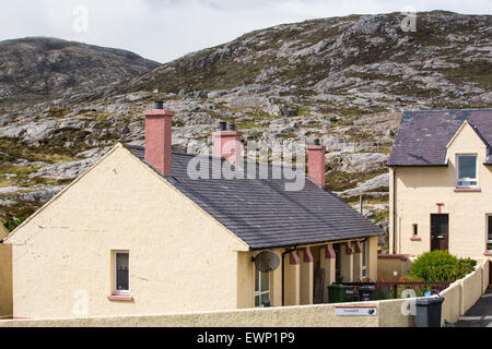 Housing in Tarbert on the Isle of Harris, Outer Hebrides, Scotland, UK, with rugged scenery behind. Stock Photo