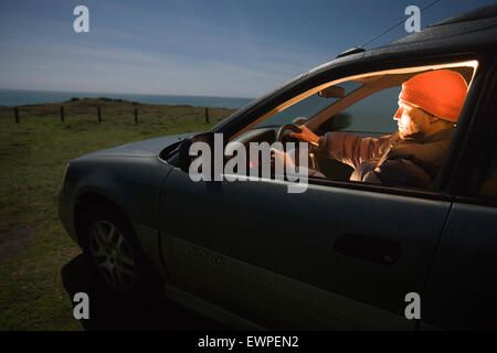 Man stopped in a car at night Stock Photo