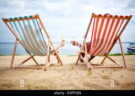 Restful couple toasting with cocktails on the beach Stock Photo