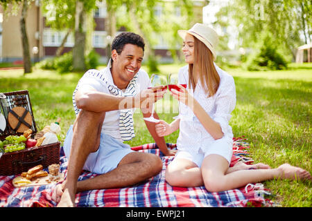 Happy young couple having picnic in park