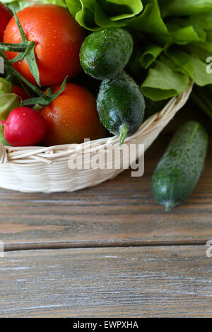 set of fresh vegetables in a basket, (cucumber, tomatoes, cabbage, greens) Stock Photo