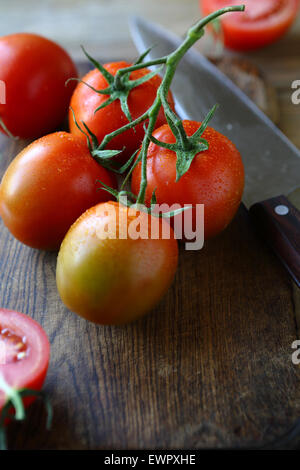 fresh tomatoes on the old board, cooking Stock Photo