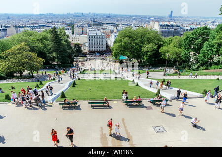 Crowds of tourists on stairs of Sacre Coeur, Montmartre, Paris, France.  View over Paris in summer Stock Photo