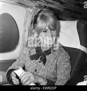 Brigitte Bardot, french film actress, flies in from Orly Airport Paris, to complete scenes on her new film, The Adorable Idiot, in London, pictured arriving at London Heathrow Airport and on aircraft, being interviewed by The Daily Mirror's Donald Zec, 23 Stock Photo