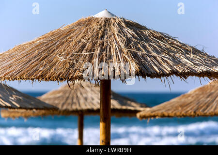 Straw beach umbrella on Rethymno Crete beach Greece Europe Stock Photo