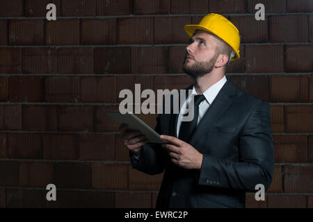 Portrait Of Construction Master With Personal Computer In Hands Stock Photo