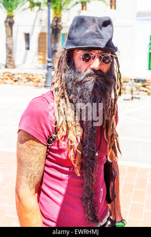 Hippy dreadlocks beard hat glasses tattoos mean looking man Ibiza Spain Spanish resort Stock Photo