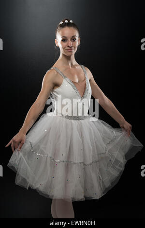 1950s BRUNETTE BALLERINA WEARING TUTU STANDING EN POINTE BEFORE STAGE  CURTAIN LOOKING AT CAMERA HANDS ON HIPS - d2445 HAR001 HARS JOY LIFESTYLE  FEMALES JOBS HEALTHINESS COPY SPACE FULL-LENGTH LADIES PERSONS ENTERTAINMENT