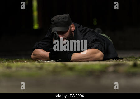 Action Hero Muscled Man Holding Machine Gun - Lying In Abandoned Building Wearing Green Pants Stock Photo