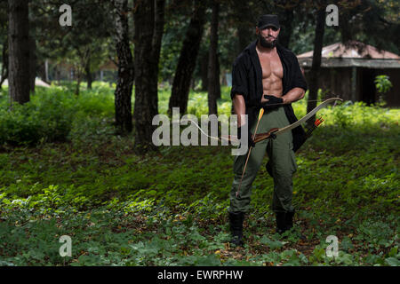 Beard Man With A Bow And Arrows In The Woods Stock Photo
